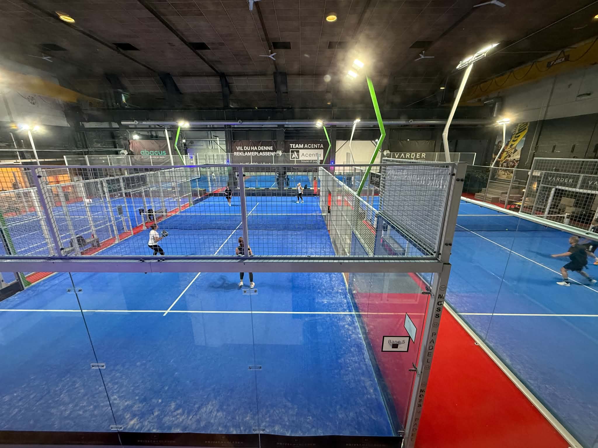 Oversikt over spillehallen i Moss Padelsenter, med spillere i gang på flere baner samtidig